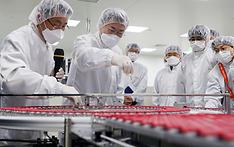 SK바이오사이언스 공장에서 코로나19 백신 생산 현장을 시찰하며 완성된 백신을 살펴보고 있다.