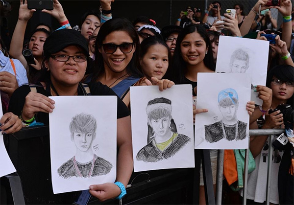LA에서 열린 KCON 2014에서 팬들이 방탄소년단의 초상화를 들고 있다. - 사진 출처: AFP PHOTO/Mark RALSTON