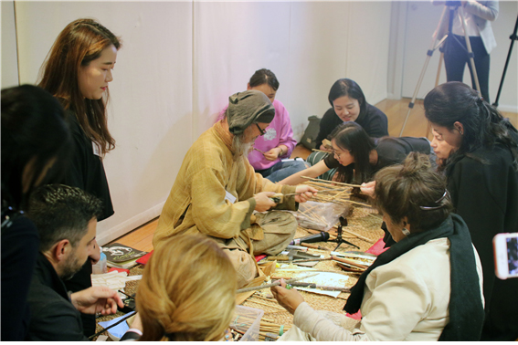 관객들과 함께 '분디나무 젓가락' 만들기 중인 이종국 작가 – 출처 : 통신원 촬영