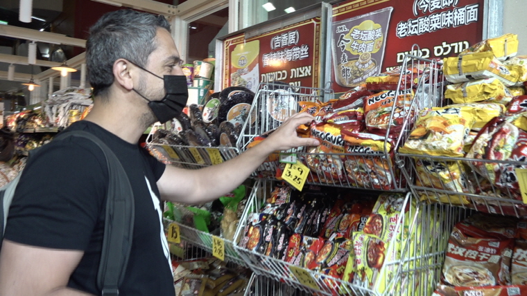 Jewish customer shopping for Korean ramyeon at an Asian supermarket in Tel Aviv