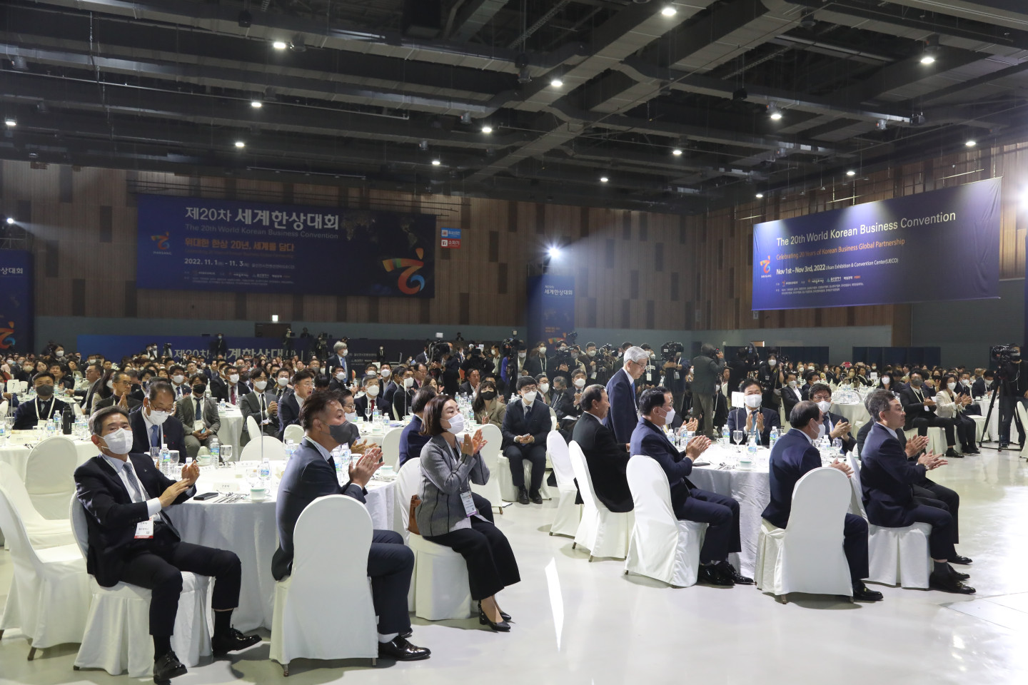 Participants enjoying their luncheon as they celebrate the opening of the 20th Korean World Business Convention while waving the convention