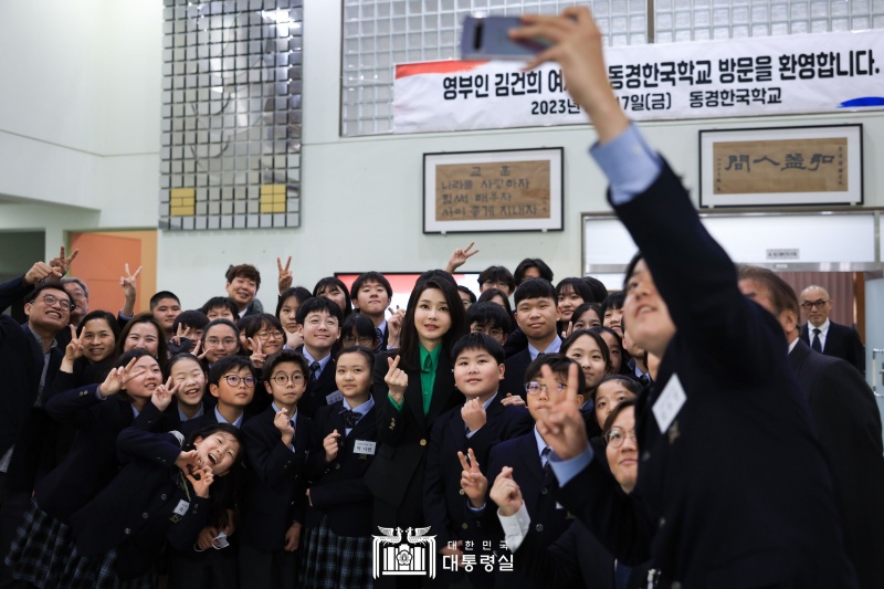 First lady Kim Keon Hee on March 17 takes a photo with students at Tokyo Korean School in the city's Shinjuku district. "Politics has borders but not culture and education," she said. "I ask you, as symbols of exchanges between both countries, to play the role of a bridge to further strengthen bilateral relations."