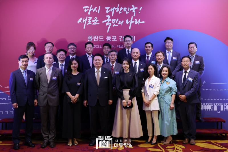 President Yoon Suk Yeol (fourth from left in front row), on an official visit to Poland, and first lady Kim Keon Hee (fifth from left in front row) on July 12 at a Warsaw hotel pose for a group photo with Korean expats in the Eastern European country at a roundtable event.