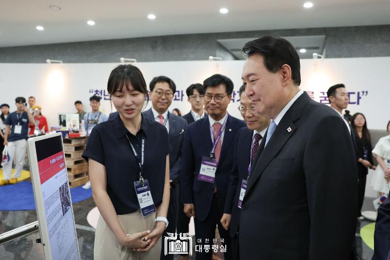 President Yoon Suk Yeol on July 5 listens to a visiting young scientist at the promotional booth of a participating country at the inaugural World Congress of Korean Scientists and Engineers held at the Korea Science and Technology Center in Seoul's Gangnam-gu District.